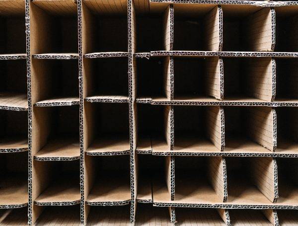Top view of corrugated cardboard box with wine bottle slots, highlighting sustainable packaging for safe wine transportation and beverage logistics. Emphasis on eco-friendly materials in shipping.